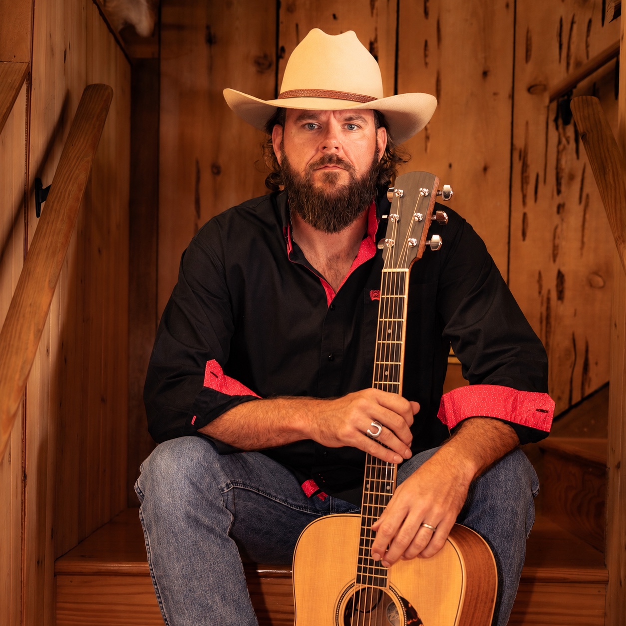 PJ Pettijohn wearing a cowboy hat and holding his acoustic guitar